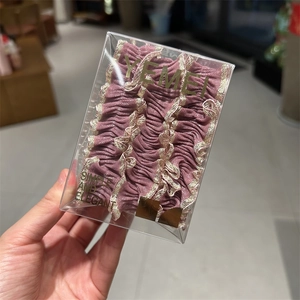 Élastiques à cheveux roses en dentelle avec bordure dorée dans une boîte cadeau élégante