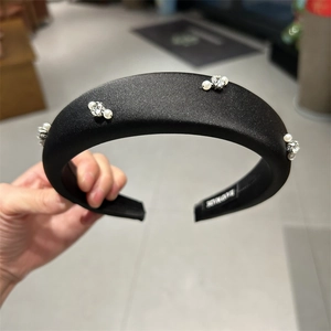Detailed view of handmade black satin headband with pearls and sparkling rhinestones