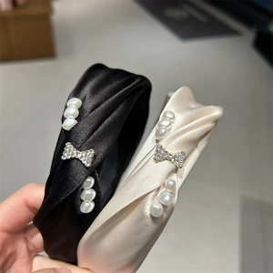 Detail view of French vintage padded headband with pearls and rhinestone bow ornament