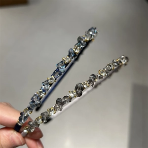 Close-up of beaded crystal headbands in blue and grey showing shiny rhinestone details