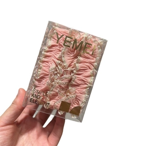 Chouchou rose à volants avec bords dorés dans un emballage cadeau transparent
