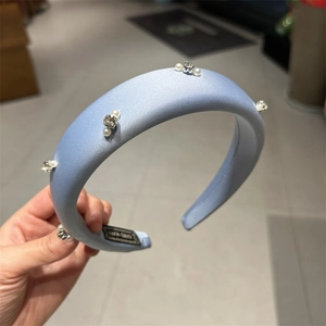 Blue padded sponge headband with rhinestone and pearl embellishments in matte satin