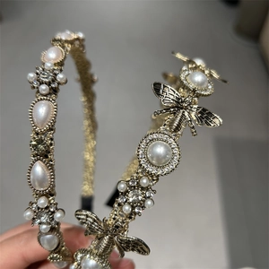 Detail of vintage gold headband featuring pearls, crystals, and delicate metal bees