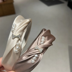Detail of satin headbands with shimmering pearls and rhinestone bow embellishments