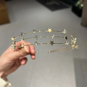 Detail of a triple-layer gold headband with star charms and sparkling rhinestones