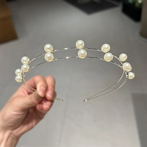 Detail shot of a double-layered silver headband with white pearls for elegant styling