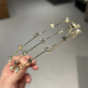 Detail of gold layered headband with metallic stars and sparkling rhinestones for hair