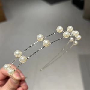 Detail view of double-layer silver headband with shiny pearls and metallic finish