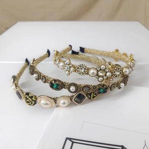Detailed shot of vintage baroque headbands featuring pearls and emerald crystals