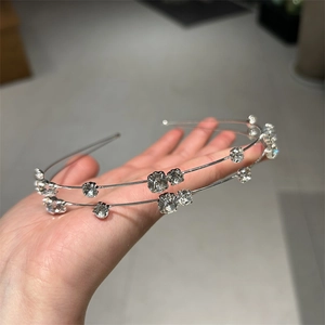 Detail of a thin double-layer silver headband with sparkling clear rhinestones for women