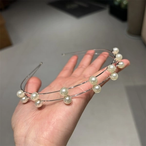 Detail of elegant double-layered metal headband with white pearls and rhinestones