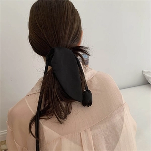 Dettaglio dell'elastico per capelli con nastro in raso nero e drappeggio elegante