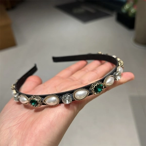 Close-up detail of vintage headband featuring waterdrop pearls and emerald rhinestones