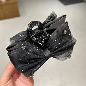 Detail der schwarzen Haarklammer mit Strasssteinen und mehrlagigen Organza-Bändern