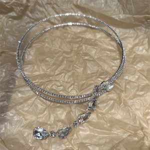 Detail der silbernen doppelten Choker-Halskette mit Zirkon-Tropfenanhängern und Quasten
