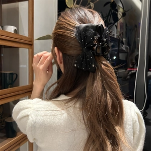 Detail der eleganten schwarzen Organza-Schleife Haarklammer mit glänzenden Strasssteinen