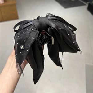 Detail von elegantem schwarzen Organza-Bogen Haarklammer mit glänzenden Strass
