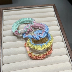 Elastic pleated hair scrunchies with plastic beads in macaron colors, set of four items