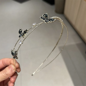 Detailed close-up of double-layer metal headband with black butterflies and clear zircons