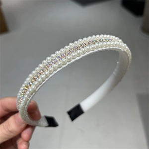 Détail d'un serre-tête vintage orné de perles blanches et de strass brillants et colorés