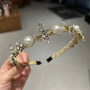 Detail of vintage gold bee headband with white faux pearls and crystals on twisted band