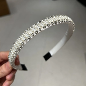 Détail d'un élégant serre-tête en satin blanc avec perles et strass scintillants