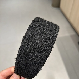Detail of black tweed headband with woven texture and subtle metallic shimmer