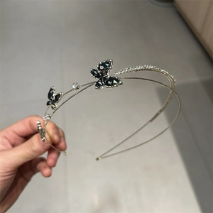 Detailed close-up of a silver double-layer headband with rhinestones and black butterflies