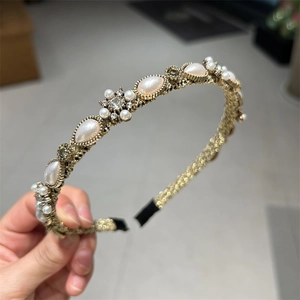 Close-up of vintage gold pearl headband with teardrop pearls and rhinestone flowers