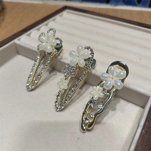 Barrettes à fleurs élégantes avec perles et strass sur une base en métal doré