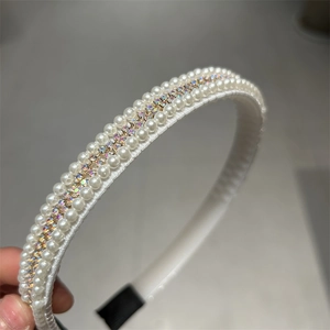 Détail d'un serre-tête élégant orné de perles blanches et de strass irisés brillants