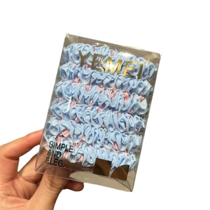 Pastel blue and pink pleated hair scrunchies set in a transparent gift box