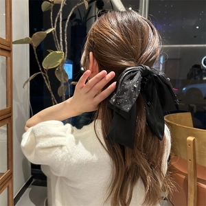 Detailansicht einer luxuriösen schwarzen Organza-Haarklammer mit silbernen Pailletten