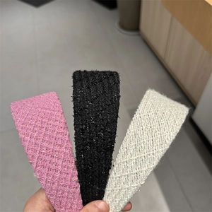 Detailed close-up of tweed braided headbands in pink, black and white color options