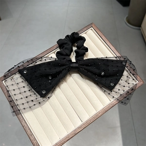Detail der eleganten schwarzen Organza-Schleifen-Haarklammer mit Strass und Perlen