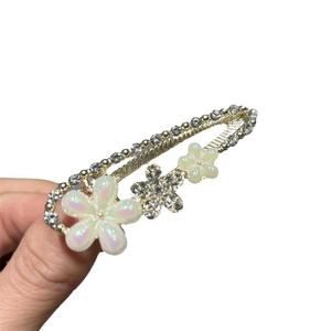 Pince à cheveux fleurie élégante avec pétales en résine blanche et strass brillants