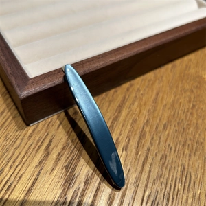 Barrette à cheveux bleu marine mat minimaliste sur un plateau en bois élégant