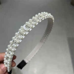 Détail d'un serre-tête vintage avec trois rangées de perles et strass brillants