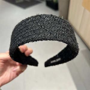 Detail of hand made label on black tweed headband with elegant silver shimmer texture
