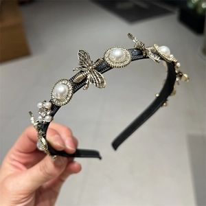 Detail of thin black headband featuring vintage gold bee and pearl embellishments