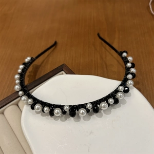 Detail of handcrafted headband with alternating white pearls and black faceted crystals