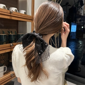 Detail einer großen schwarzen Organza-Haarschleife mit Pailletten für Pferdeschwänze