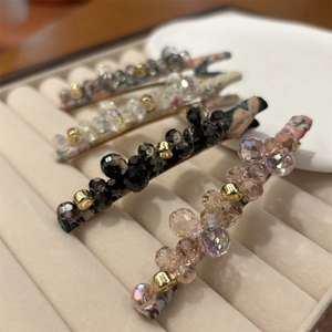 Detailed view of handmade crystal beaded hair clips in four elegant colors on velvet display