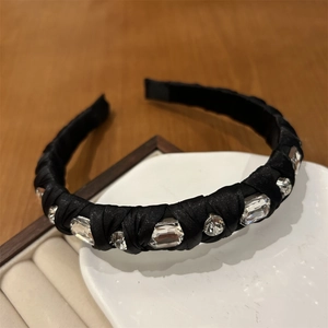 Detail of a black satin headband with sparkling rectangular and round rhinestones