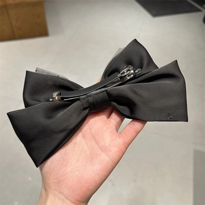 Detail der schwarzen Satin-Schleifen-Haarklammer mit Netzspitze und Metall-Clip