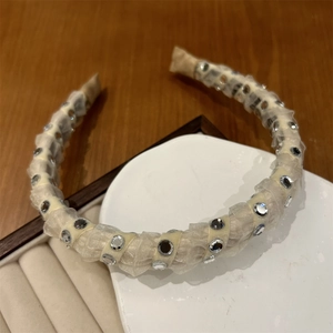 Detail of elegant rhinestone headband with creamy chiffon fabric and mirror accents