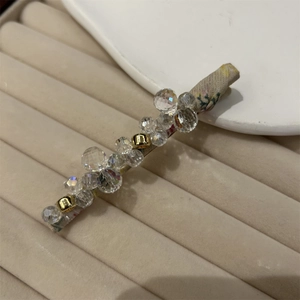 Detail of floral fabric hair clip with clear crystal beads and gold metal accents