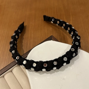 Detailed view of elegant black pleated headband with sparkling rhinestone embellishments
