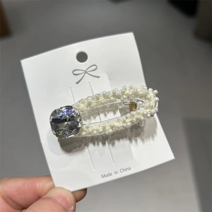 Dettaglio di fermaglio per capelli in perle con zircone quadrato su cartoncino