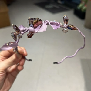 Detail shot of purple silk ribbon headband decorated with crystal beads and a delicate bow